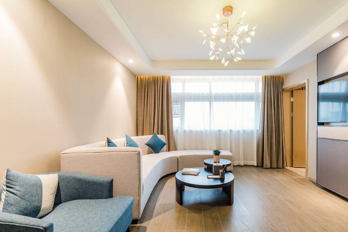 A modern living room with a sofa, a coffee table, and a TV.