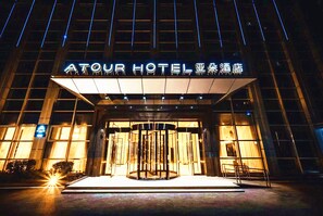 The exterior of the Atour Hotel with illuminated signage and a revolving door entrance. - Atour Hotel Lugu Changsha (Changsha)
