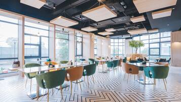 A modern conference room with large windows, a geometric patterned floor, and contemporary furniture.