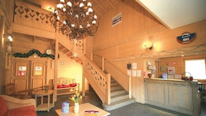 A wooden interior with a staircase, a reception desk, and a dining area. - Appartement sympa et équipé, proche de le Navette (Samoëns)
