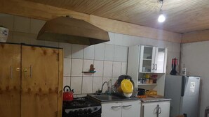Una cocina con armarios blancos, estufa, fregadero y refrigerador.