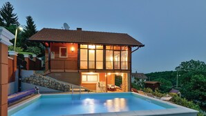 Ein zweistöckiges Haus mit einem Schwimmbad davor.