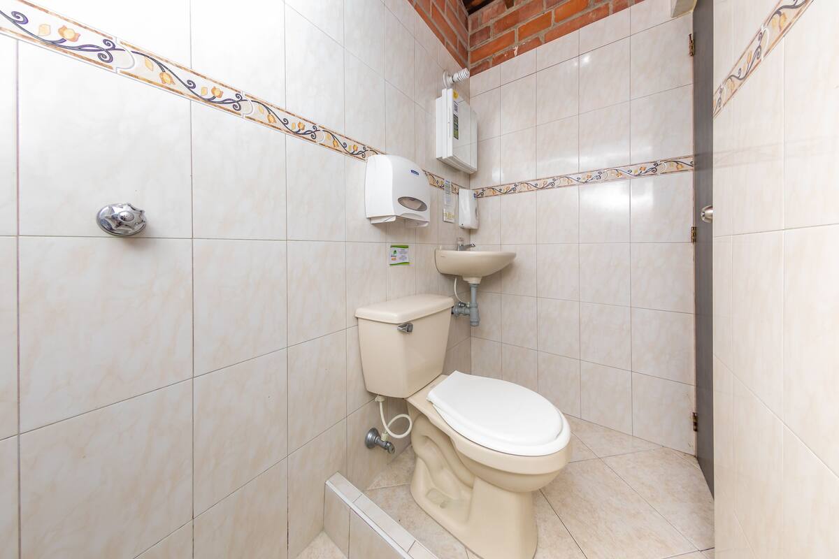 Een badkamer met toilet, wastafel en handdroger.