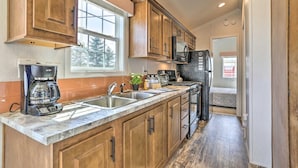 A kitchen with wooden cabinets, a stainless steel sink, a coffee maker, and a microwave. - Equestrian House- Dosanko Cottage (Pleasant Mount)