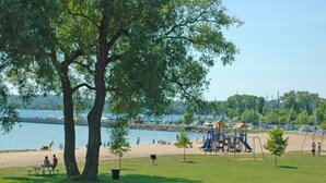 A park with a playground, picnic tables, and a lake view. - Walk everywhere in the adorable village of Suttons Bay. (SUTTONS BAY)