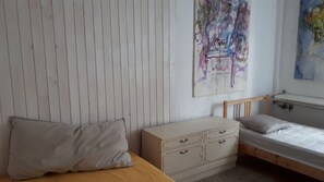A bedroom with a bed, a dresser, and a painting on the wall. - house in the green - just 10 minutes from the cathedral and 20 minutes by car to the airport (Kalscheuren)