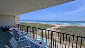 Un balcone con vista sulla spiaggia e sull'oceano. Sono presenti due poltrona prendisole e un tavolino.