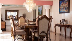 A dining area with a wooden table, ornate chairs, and a chandelier. - Spacious & Comfortable Penthouse in DR (Santo Domingo)
