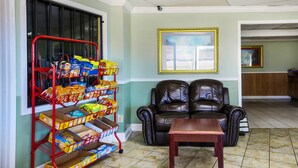 Una sala de estar con un sofá de cuero, una mesa de centro y un carrito de aperitivos lleno de papas fritas y bocadillos.