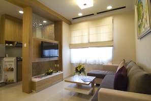 Relax in this stylish living room with a flat-screen TV, comfortable sofa, and kitchenette.
