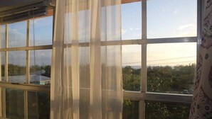 A window with multiple panes and a sheer curtain. -   "The Most Convenient Location To Vacation" (Governor's Harbour)