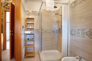 Een douche, een haardroger, een bidet, handdoeken