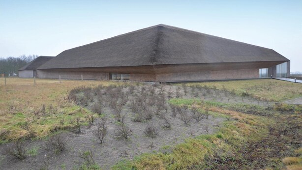 A large, modern building with a flat roof and a long, rectangular structure.