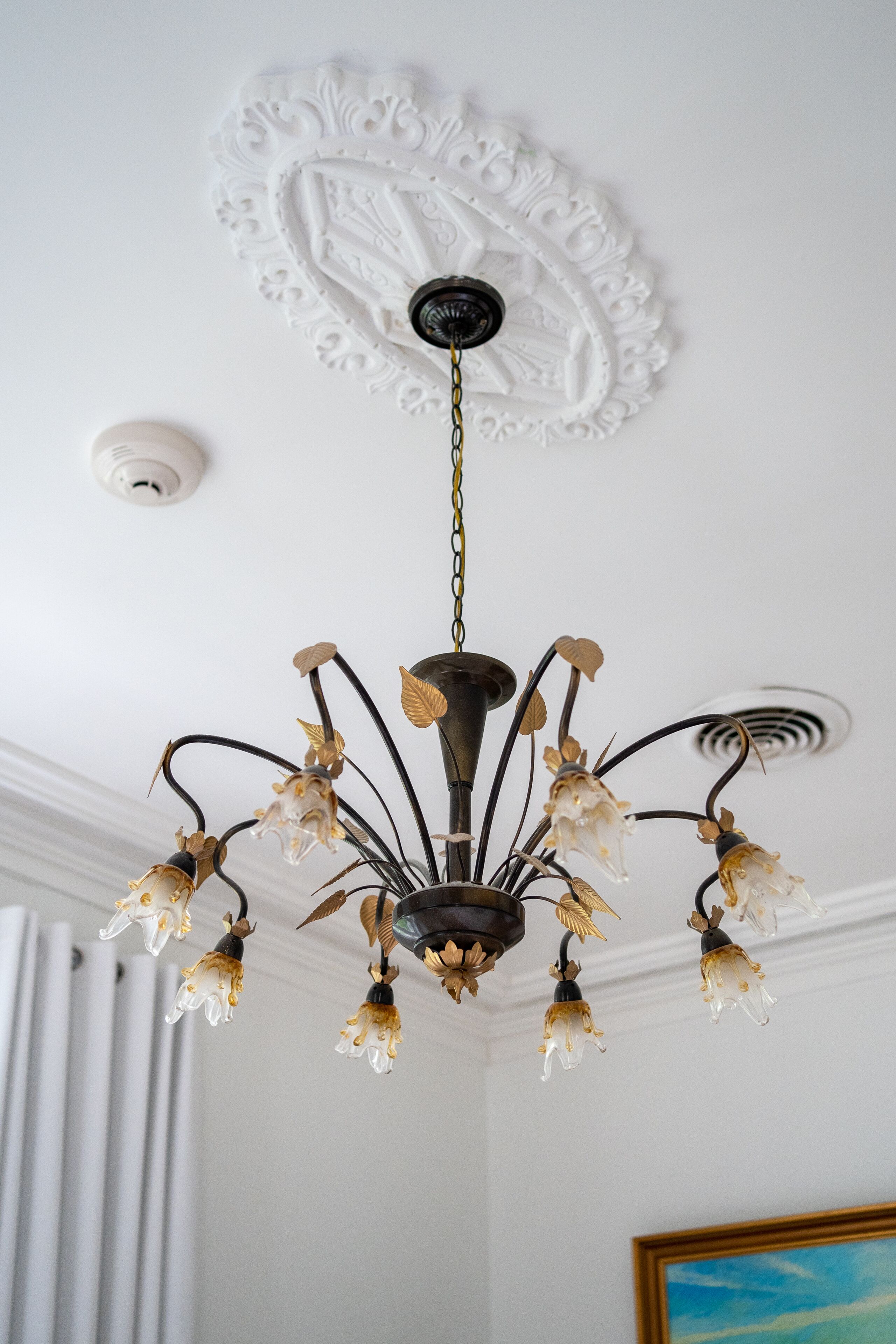 A chandelier with multiple light fixtures and a decorative ceiling medallion.