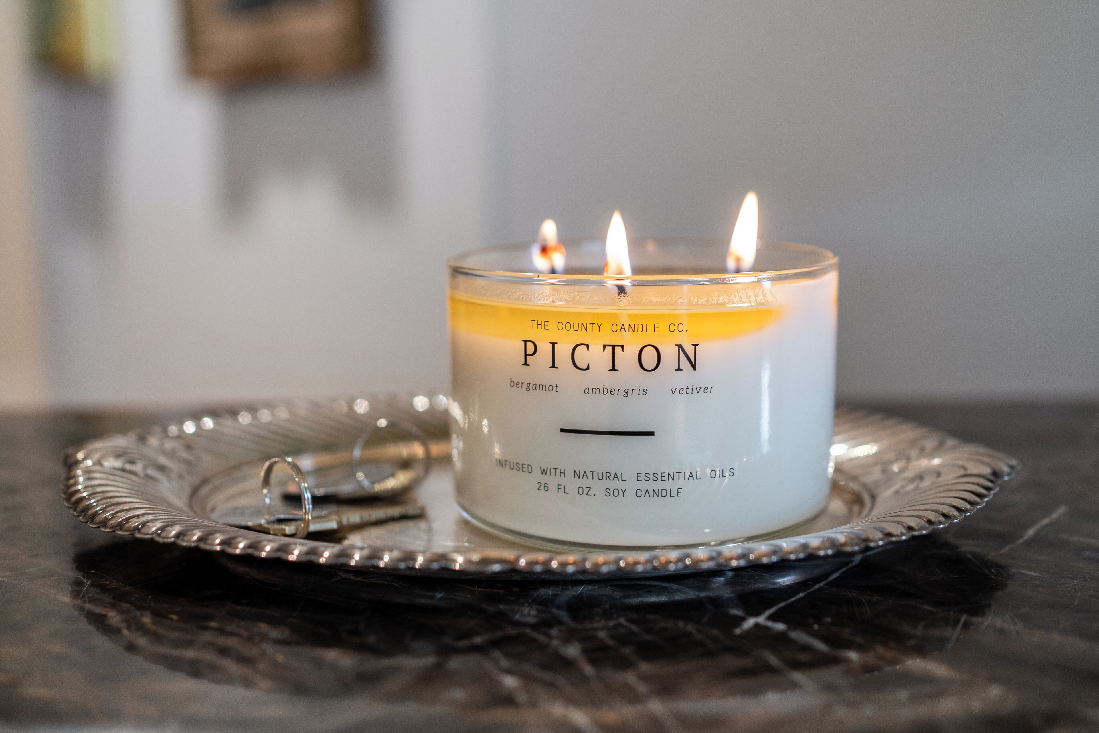 A lit Picton candle on a silver tray.