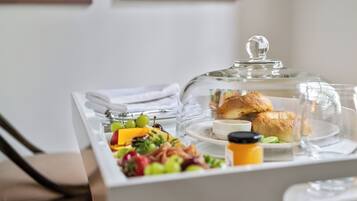 Een ontbijtbuffet met diverse soorten fruit, gebak en een vitrine.
