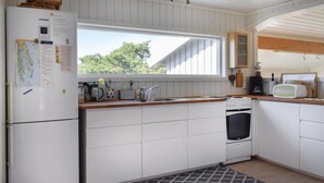 A kitchen with white cabinets, a stove, a sink, and a window. - Awesome home in Sandefjord with WiFi (Sandefjord)