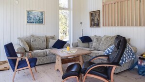 A cozy living room with a sofa, two armchairs, a coffee table, and a painting on the wall. - Awesome home in Sandefjord with WiFi (Sandefjord)