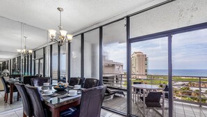 Ein moderner Essbereich mit Blick auf das Meer und einem Hochhaus im Hintergrund.