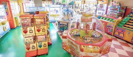 A row of colorful arcade machines in a brightly lit indoor space.