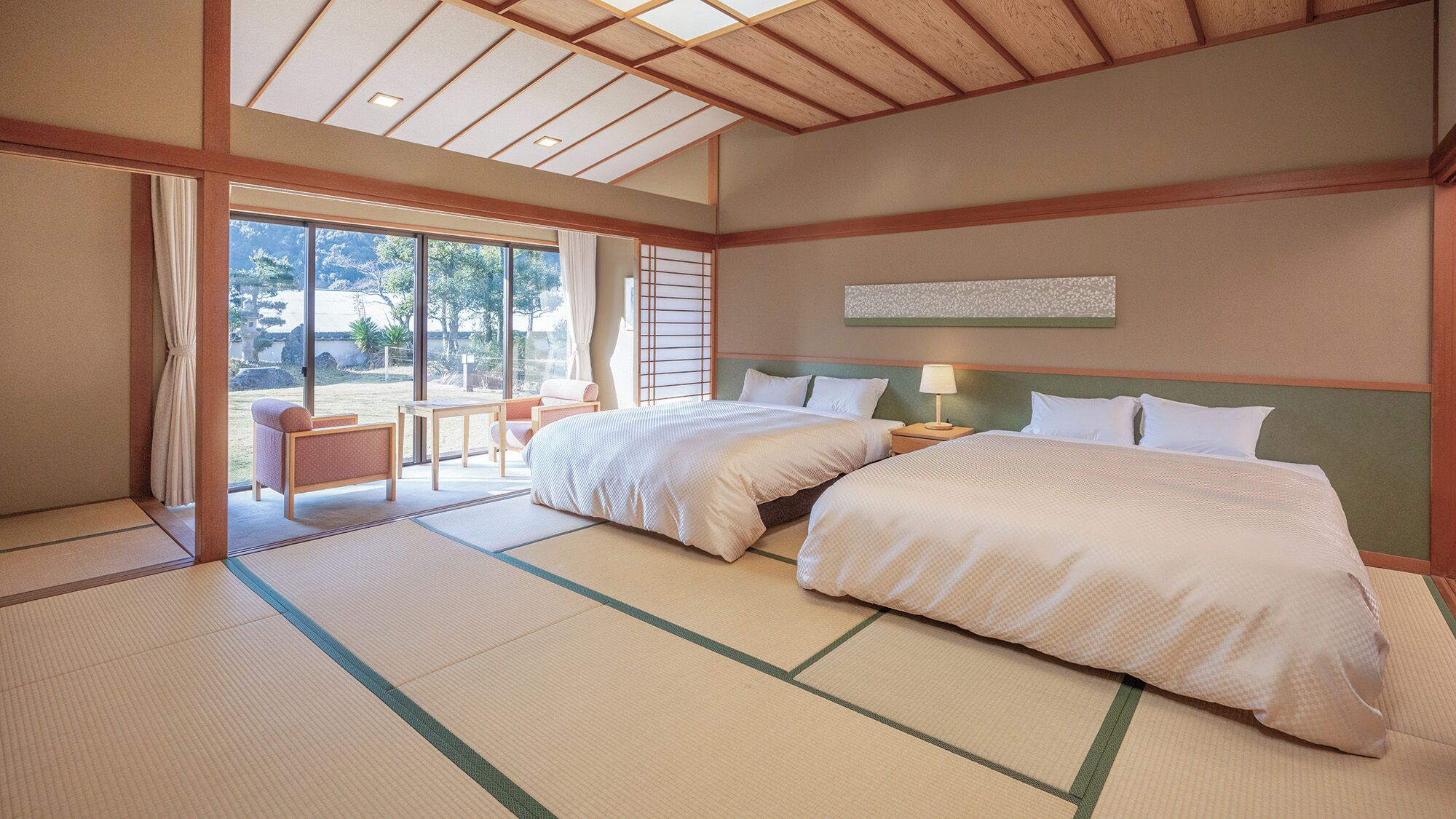 Een hotelkamer met twee bedden, uitzicht op de omgeving en tatami vloeren.