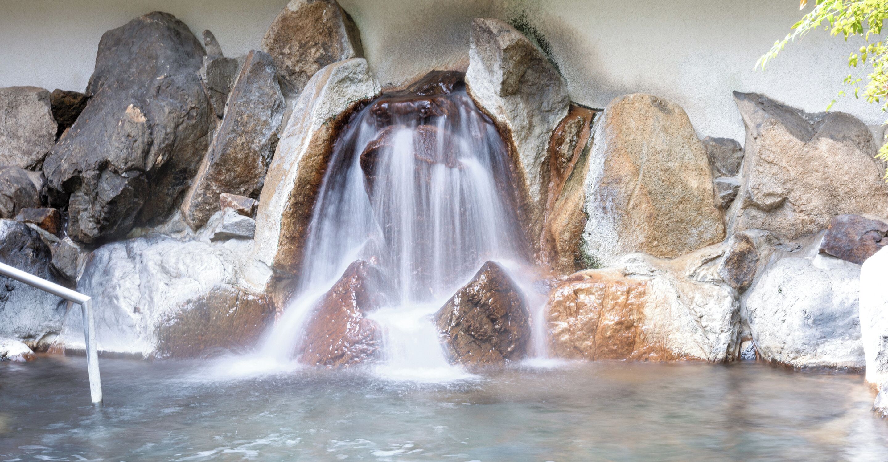 A waterfall cascading over rocks into a pool.