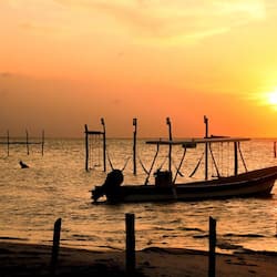 Moored in calm waters, this traditional boat offers a serene coastal escape.