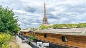 A boat with a wooden deck and a sign indicating "BNB SITTER". - MAGNIFICENT APARTMENT NEAR THE EIFFEL TOWER (Paris)