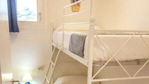 A bunk bed with a ladder, a bedside table with a lamp, and a window with curtains. - Affittimoderni Viddalba Bouganville - VIBO21 (Viddalba)