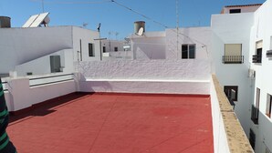 A rooftop terrace with red flooring, white walls, and satellite dishes. - Central apartment on the first floor (CONIL DE LA FRONTERA)