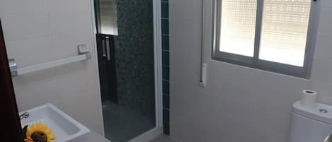 Un baño con bañera, inodoro y ducha.