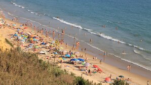 A beach with people, umbrellas, and a sandy shore. - Central apartment on the first floor (CONIL DE LA FRONTERA)
