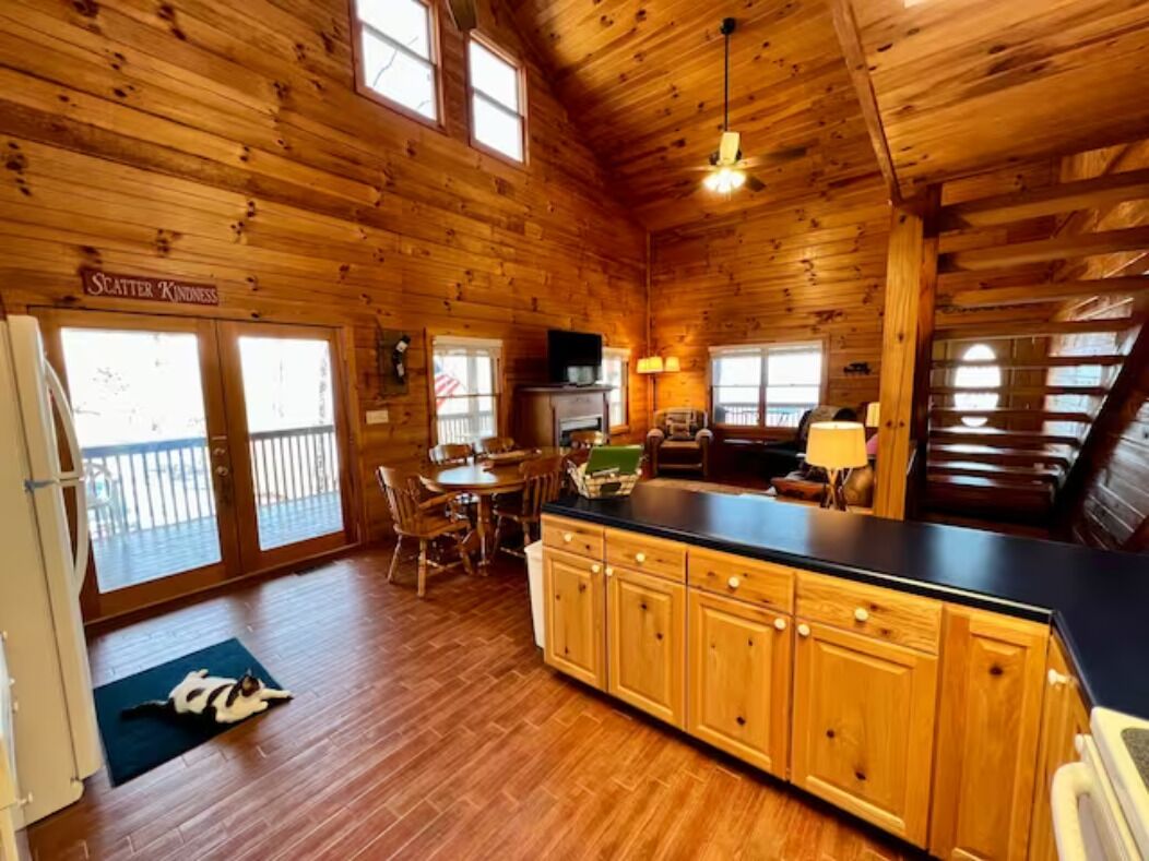 L’intérieur d’un chalet en bois comprend une cuisine, un coin repas et un balcon.