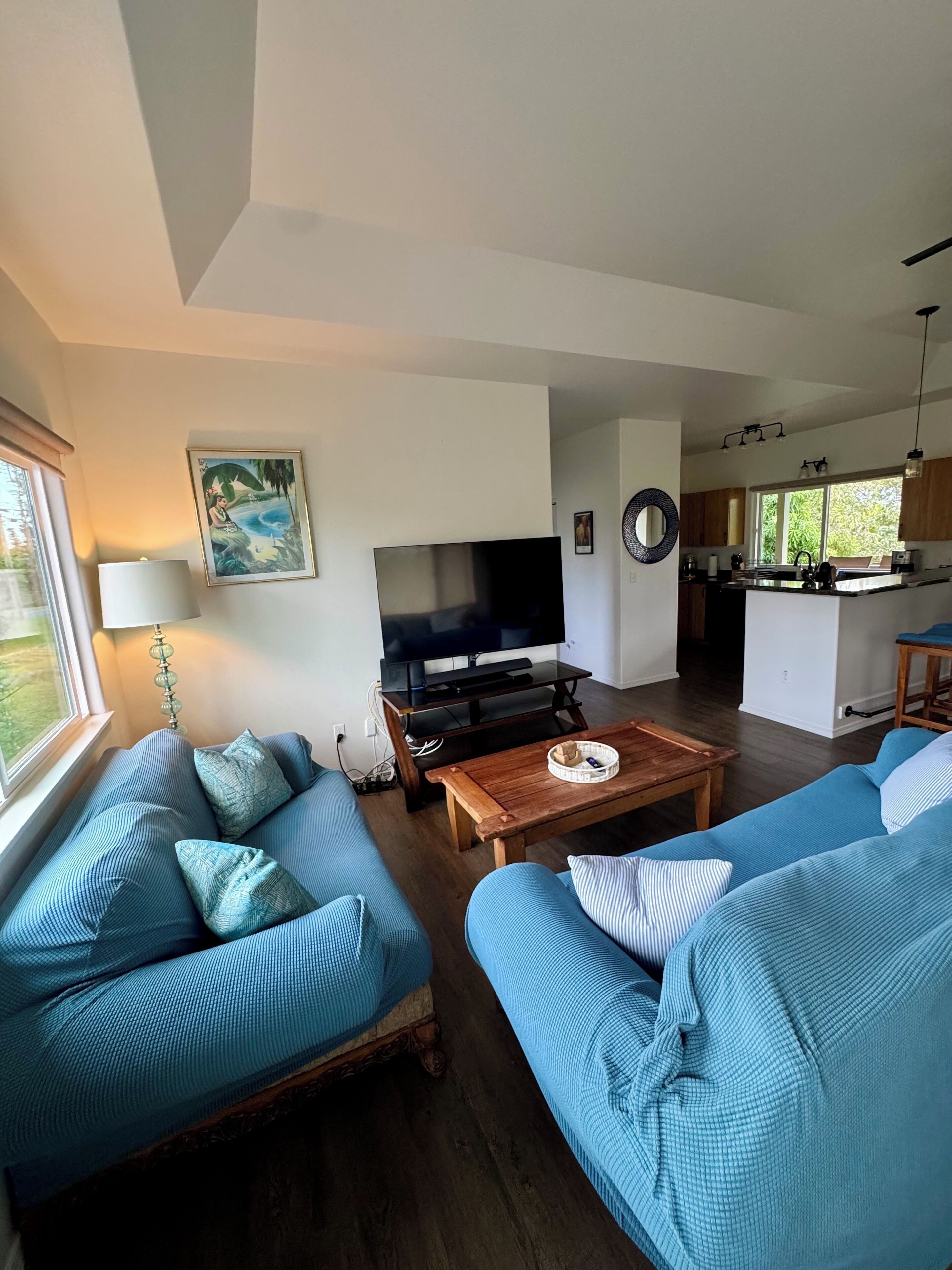 Living room view of sofa & loveseat & 55” smart tv from teak desk