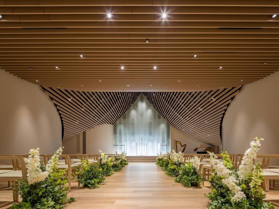 A church interior with wooden pews, a central aisle, and a harp.