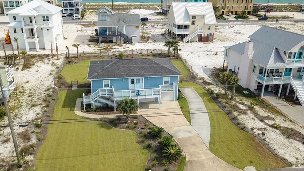 A coastal residential area with houses, a beach, and a clear view of the ocean.