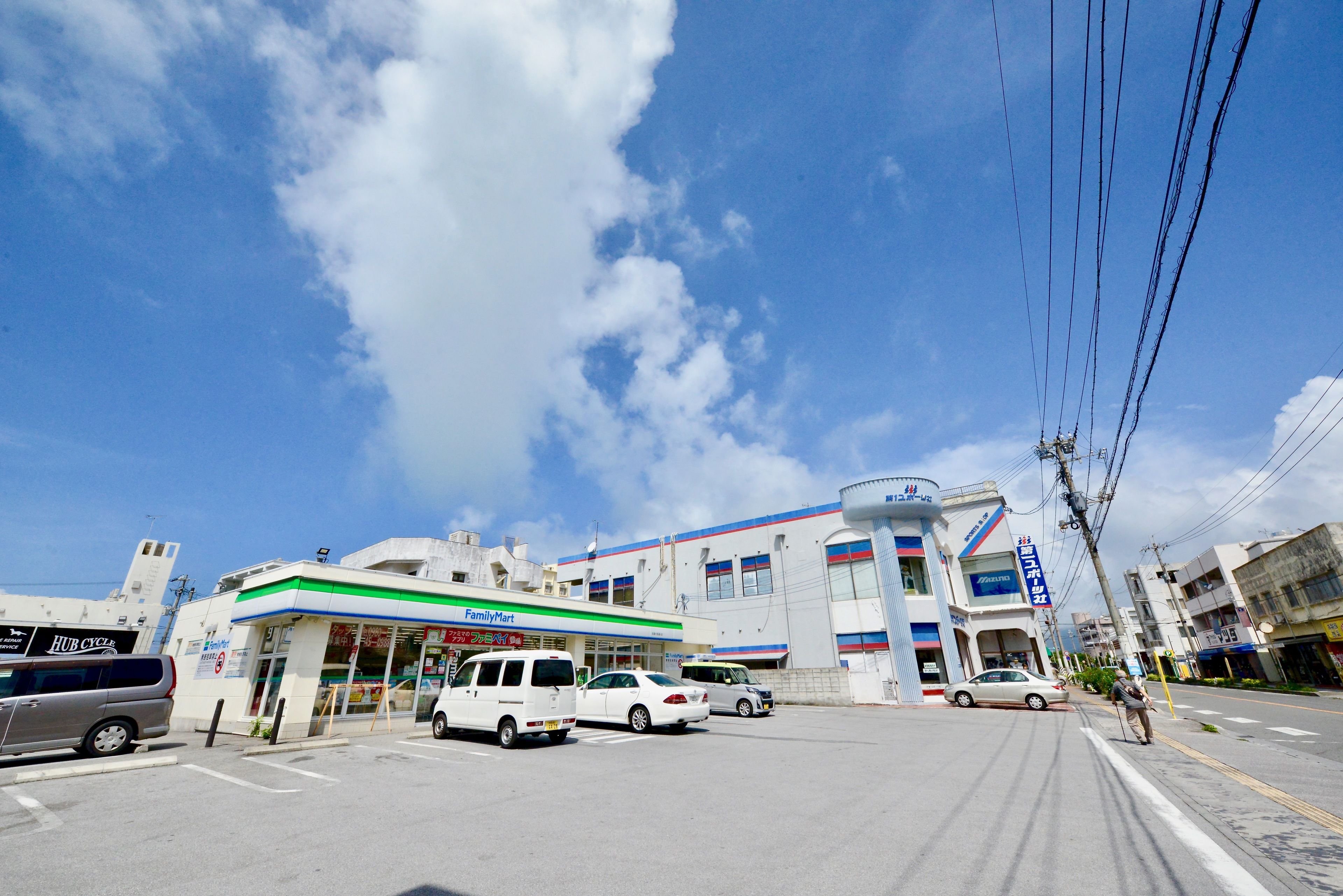 A FamilyMart store with a white van parked in front.