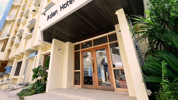 The exterior of the Adan Hotel with a modern facade, large glass entrance, and a visible balcony on the left. - Adan Hotel (Nago)