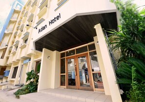The exterior of the Adan Hotel with a modern facade, large glass entrance, and a visible balcony on the left. - Adan Hotel (Nago)