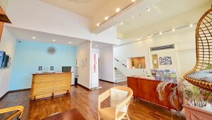 A spacious lobby with a reception desk, a staircase, and a seating area. - Adan Hotel (Nago)