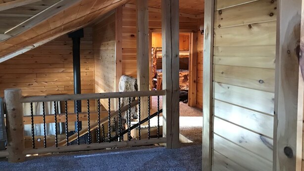 Un interior de madera con una escalera que sube a un nivel superior.