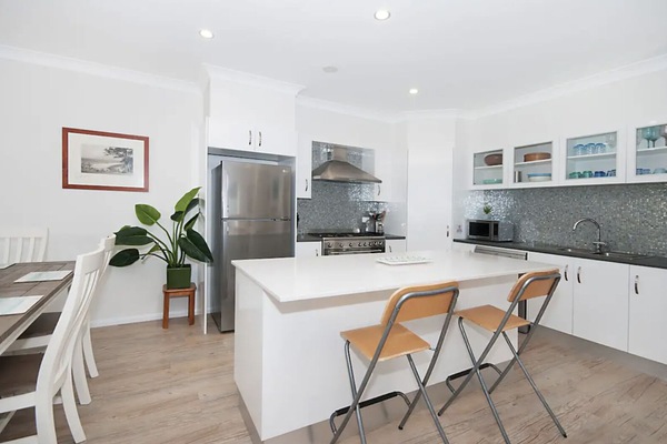 Kitchen. Oversize gas stove, SS appliances, stone bench top glass tiles. Fully equipped!