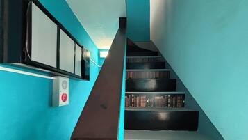 A staircase with a blue wall and a white handrail.