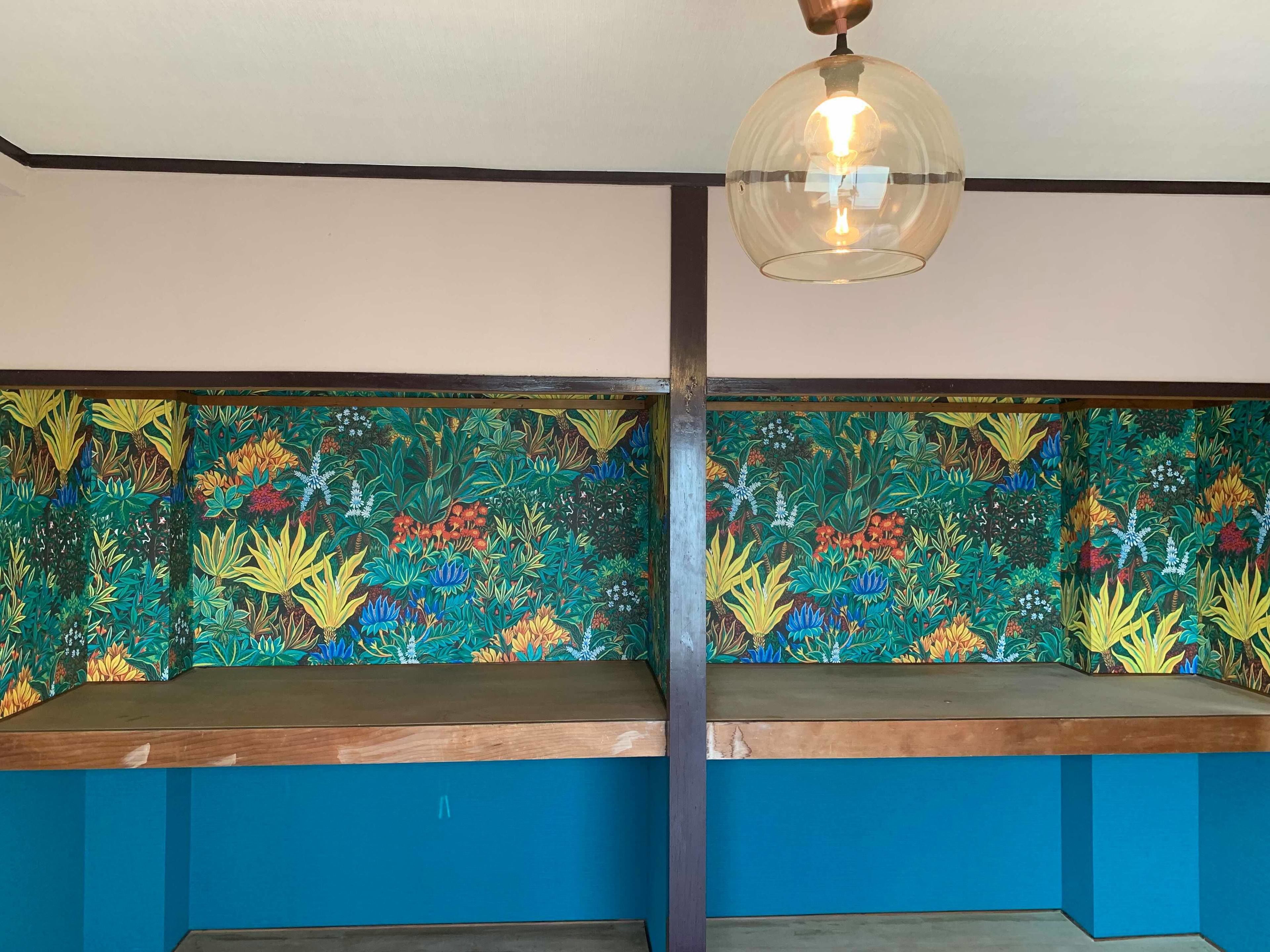 Habitació amb una banca de fusta i un mural de paret colorit.