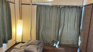 A room with a bed, a standing lamp, and a large window with curtains. - 777 Takamatsu Guest House (Takamatsu)