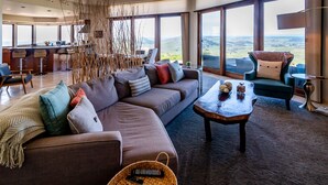 Un salon moderne avec un grand canapé, une table basse et une vue sur la campagne.