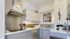 Una cocina moderna con electrodomésticos de acero inoxidable, lavavajillas y un cubo de basura.