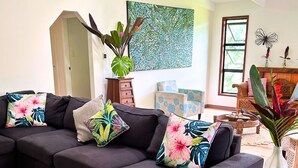Ein modernes Wohnzimmer mit einem Ecksofa, einem kleinen runden Tisch und einem großen Fenster.