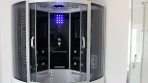 Un moderno spa con paredes cerradas, un panel de control y una silla de masaje.