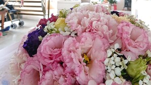 A staircase with ornate metal railings and a floral arrangement on a table. - Straybirds BnB (Donghe)